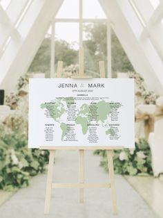 an easel with a world map on it in front of a wedding ceremony venue