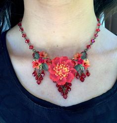 We call this color flame.  Bright red off set with hints of hot pink and orange make this a stunning necklace.  The center large flower is the focal point bordered with pretty drops on either side. The flowers are resin and are all individually hand painted. The whole piece is hand beaded with glass beads. This is a quality piece of jewelry that will last a life time. Created by designer Colleen Toland who has been creating her unique style of vintage jewelry for more than 30 years. All of our p Red Flower-shaped Beaded Necklace For Gift, Red Flower-shaped Beaded Necklaces For Gifts, Handmade Red Flower Beaded Necklaces, Handmade Red Beaded Flower Necklaces, Unique Red Flower-shaped Jewelry, Unique Red Flower Shaped Jewelry, Unique Red Flower Jewelry, Handmade Red Flower Jewelry, Red Bohemian Flower Pendant Jewelry