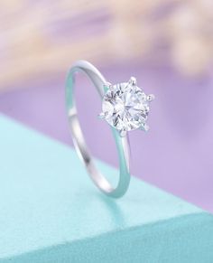 a diamond ring sitting on top of a blue box