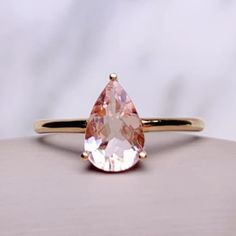 an orange and white ring with a pear shaped stone on it's center piece