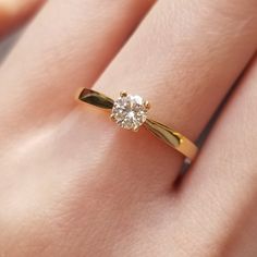 a close up of a person's hand with a diamond ring on their finger