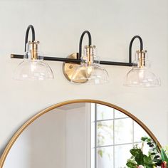 a bathroom vanity light with three lights and a mirror in front of the sink area