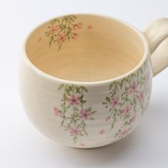 a white cup with pink flowers on it