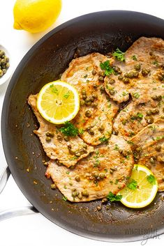 some food is cooking in a pan with lemons