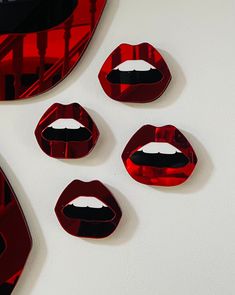 four red lips are arranged on a white surface