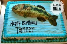 a birthday cake with a large fish on it's icing and the words happy birthday tanner written in black