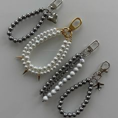 three different types of beaded bracelets and charms on a white surface with gold clasps