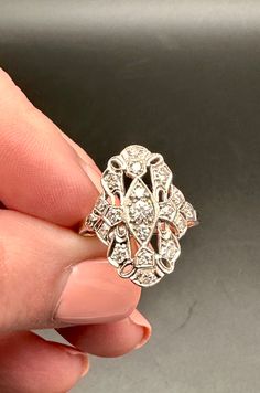 a woman's hand holding an antique diamond ring