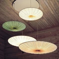 three circular lights hanging from the ceiling in a room with wood paneled walls and ceilings