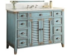 a bathroom vanity with an antique blue finish and white marble counter top, along with a large mirror above the sink