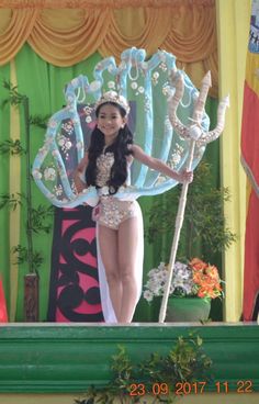 a woman in a costume standing on stage with an umbrella