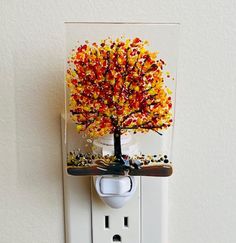 an electrical outlet with a colorful tree on it