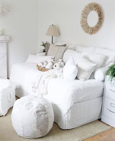 a white bed sitting in a bedroom on top of a hard wood floor