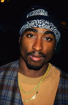 a close up of a person wearing a beanie and looking at the camera with a serious look on his face