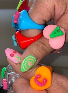 a person with colorful nail polish on their fingers and some plastic objects in the background