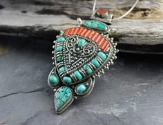 Gran colgante tradicional tibetano con incrustaciones de piedras de coral y turquesa.

 Tamaño: 3 por 1 3/4 pulgadas



 La cadena se vende por separado. Colgante que se muestra en nuestra cadena de serpiente de ley. Traditional Turquoise Inlay Necklace As Gift, Traditional Turquoise Jewelry With Large Pendant, Traditional Turquoise Necklace With Inlay For Gift, Bohemian Turquoise Pendant Necklace With Stones, Traditional Turquoise Pendant Necklace With Natural Stones, Traditional Turquoise Medallion Jewelry, Bohemian Turquoise Multi-stone Pendant Necklace, Traditional Multi-stone Turquoise Necklace As Gift, Cactus Inspiration