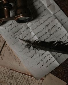 an old paper with writing and a feather quill on it next to a pair of binoculars