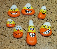 six orange and white candy candies with faces painted on them