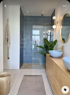 a bathroom with two sinks and a large mirror on the wall next to a walk in shower