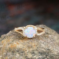 a white opal ring sitting on top of a rock