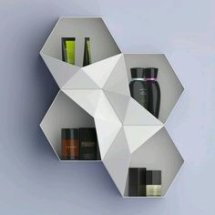 a white shelf with some bottles and containers on it's sides in the shape of an origami hexagon