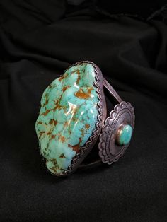 For Sale.  HUGE! Monster! Dry Creek Nevada Turquoise bracelet!  EXTREMELY WELL MADE BRACELET! HEAVY DUTY! SOLID SILVER! WITH SIDE CONCHOS ONE ON EACH SIDE WITH A MATCHING DRY CREEK TURQUOISE  CENTER STONES! THIS IS AN AMAZING SHOW STOPER BRACELET! WITH EXTREMELY RARE HUGE!  DRY CREEK TURQUOISE! Over 600 carats! One of Lander county Nevada's most prolific turquoise mines!  Dry Creek is known for its super hard gem and taking a great polish!  This monster dry creek turquoise stone is  2 - 1/2 inches wide by  3 - 5/8ths inches long and 5/8ths inch plus thick!  The Bracelet opening is 1 - 5/8ths inches!  The Bracelet  inside diameter is 5 - 1/2 inches! This Beautiful Bracelet is Supper well made of heavy thick silver work with incredible bezel work around the turquoise! this bracelet is made f Antique Turquoise Jewelry Gold, Artisan Turquoise Round Bracelet, Turquoise Bracelet With Patina As A Gift, Luxury Handmade Turquoise Bracelet, Luxury Handmade Turquoise Bracelets, Turquoise Patina Bracelet, Turquoise Cabochon Bracelet, Turquoise Patina Bracelet Jewelry, Turquoise Cabochon Round Bracelets