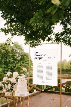 a white wedding cake sitting on top of a table next to a sign that says our favorite people