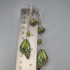 Butterfly Wing Earrings Green Monarch Butterfly Wings Earrings Long Dangle Drop Earrings Magical Fairy Wing Earrings Colorful Wing Earrings I ship super fast.  These super fun lightweight earrings are so pretty. The beads are wire wrapped and connected to the chain.  The wings are connected to the chain.  They are all gathered on a jumpring and connected to the ear wires. The wings are made of resin.  They are double-sided.  The beads are glass crystals.  The chain is non-tranish silver plated and the ear wires are Sterling Silver.  They ship with rubber backs to prevent loss in a delightful organza bag perfect for gift giving. Whimsical Green Dangle Jewelry, Whimsical Green Nickel-free Jewelry, Whimsical Green Dangle Earrings, Handmade Fairy Dangle Jewelry, Handmade Fairy Style Dangle Jewelry, Fairy-themed Drop Earrings For Gifts, Fairy Style Jewelry With Matching Earrings Gift, Green Nickel Free Dangle Chandelier Earrings, Green Nickel-free Dangle Chandelier Earrings