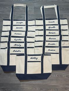 six tote bags with names on them sitting on a wooden floor next to each other