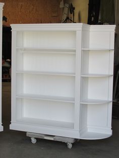 two white bookcases sitting next to each other on casteors in a garage