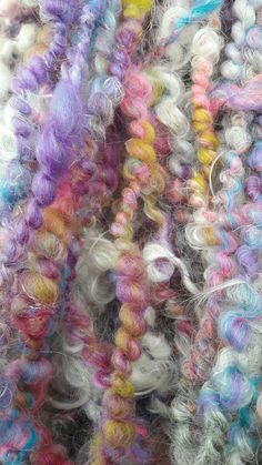 many different colored yarns are piled together