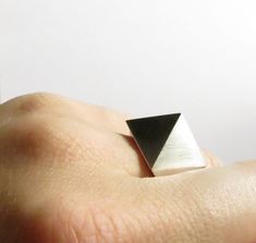 This beautiful Sterling Silver pyramid ring will become a timeless part of your collection... minimalist and contemporary, it is a solid statement piece for your collection. Handmade in my studio, and finished in a soft, satin finish, it can also be high polished upon request. This ring is made custom size to order, just add your ring size from the drop down menu, or in the note to seller when checking out. About: Materials: Sterling Silver, 925. Dimensions: top of pyramid is 16 x 16mm. Ring siz Elegant Pyramid-shaped Gift Ring, Geometric Minimalist Formal Jewelry, Minimalist Silver Pyramid Jewelry, Minimalist Pyramid-shaped Jewelry For Gifts, Modern Handmade Rings For Formal Occasions, Handmade Modern Rings For Formal Occasions, Sterling Silver Triangle Rings As Gift, Modern Sterling Silver Rings With Geometric Shape, Sterling Silver Triangle Rings For Gifts