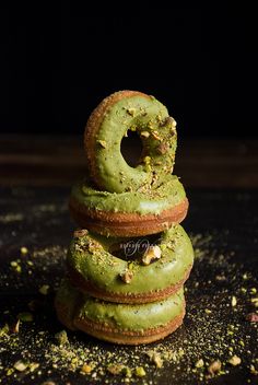 a stack of doughnuts sitting on top of each other covered in green frosting