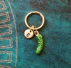 a gold keychain with a green pea charm hanging from it