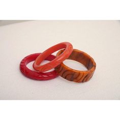 This is part of Chairish’s Costume Jewelry assortment.  The set of 3 art deco vintage authentic carved bangle bakelite bracelets are in the hues of red, amber orange and caramel. They are all hand carved and the orange caramel one is a thicker cuff with small swirls of black. The caramel on is 1.25" H x 3" W and the interior of that one is approx. 2.5" W. The other two are .5" H x 3.5" W and the other of those are 2.5" W. They will fit over a small medium wrist or medium wrist but not an extra w Red Carved Vintage Jewelry, Carved Red Vintage Jewelry, Vintage Red Round Bangle, Vintage Handmade Red Bangle, Red Retro Bangle Jewelry, Vintage Red Adjustable Bangle, Handmade Bakelite Bangle Bracelet, Brown Bakelite Bangle Bracelet, Vintage Carved Orange Jewelry