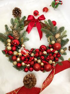 a christmas wreath with pine cones and ornaments