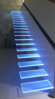 an escalator that is lit up with blue lights in the middle of it