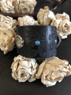 "🔸🔸orders are delayed by a few days this week. Thank you for your patience Country leather bracelet cuff, western jewelry Distressed black embossed genuine leather 1 1/2\" strap has been adorned with an antiqued silver wing attached to the leather with two textured antiqued silver rivets. Four turquoise rivets line the cuff. One antiqued silver snap has been placed to fit up to a 6 1/2\" wrist. I can add another snap for a smaller or larger wrist size but you need to convo me before purchasing Hand Tooled Brown Jewelry For Rodeo, Brown Hand Tooled Jewelry For Rodeo, Southwestern Concho Cuff Bracelet For Festivals, Western Leather Jewelry With Concho, Adjustable Western Cuff Bracelet For Festivals, Western Brown Hand-tooled Jewelry, Adjustable Western Style Cuff Bracelet For Festivals, Adjustable Western Style Festival Cuff Bracelet, Western Style Adjustable Cuff Bracelet For Festivals