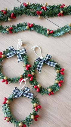 four christmas wreaths with bows and berries on them