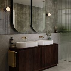 a bathroom with two sinks and three mirrors on the wall next to a walk in shower