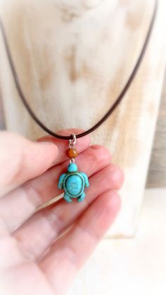 "Blue turquoise magnesite stone turtle hangs on mahogany wood bead and  brown leather cord , that finished with silver or gold metal findings . Beautiful pendant for any summer activity ! If you are looking for white turtle necklace - it's her : https://www.etsy.com/listing/467315027/sea-turtle-howlite-choker-turquoise?ref=shop_home_active_3 Size : 18 \" cord           1 \" 1/4 '  pendant with loop   If you'll need a different size - please convo me." Spiritual Turquoise Jewelry With Adjustable Cord, Handmade Adjustable Turquoise Necklace As Gift, Natural Stone Pendant On Waxed Cord, Natural Stone Pendant With Waxed Cord, Handmade Turquoise Jewelry With Waxed Cord, Adjustable Turquoise Pendant Necklace With Spiritual Style, Adjustable Spiritual Turquoise Pendant Necklace, Spiritual Adjustable Turquoise Necklace Gift, Adjustable Turquoise Amulet Necklace