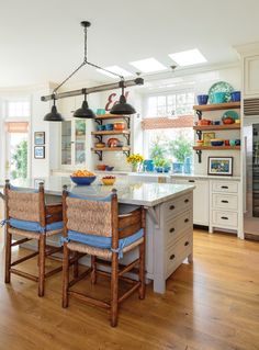 a kitchen with an island and two hanging lights