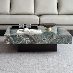 a marble coffee table sitting on top of a carpeted floor next to a couch