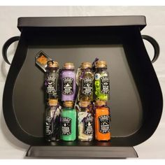 an assortment of spices and seasonings in glass bottles on a black tray with white background