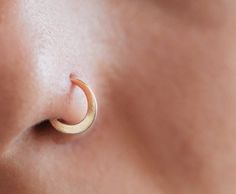 a woman's nose with a small gold ring on it