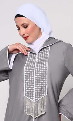 Elevate your modest fashion with our Hoodie Abaya, where contemporary style meets traditional elegance. Crafted from high-quality fabric, this abaya features intricate check embroidery, adding a touch of sophistication. The front is adorned with charming tassels that sway gracefully with your movements, creating a dynamic silhouette. Designed for both comfort and style, it includes two practical pockets, perfect for keeping essentials close at hand. Whether worn casually or for special occasions, this Hoodie Abaya promises to be a versatile and timeless addition to your wardrobe. Size & FitModel height is 5’9’’ and is wearing a Small size Material & CareMaterial: Slub PoplinCare: Gentle machine wash in cold water or Drycleaning SpecificationsSleeve Length: Full SleevesLength: Ankle Length Hoodie Abaya, Abaya With Pockets, Check Embroidery, Grey Hoodie, Modest Fashion, Ankle Length, Contemporary Style, Quality Fabric, Cold Water