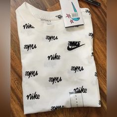 Nwt Boys Size S Basic White Shirt With Text Print, White Graphic Tee Shirt With Branding, White Graphic Tee With Branding, Basic White Tops With Letter Print, Trendy Nike T-shirt With Letter Print, Nike White Tops For Summer, Nike White Cotton Shirt, Trendy Nike Top With Letter Print, White Nike T-shirt With Text Print