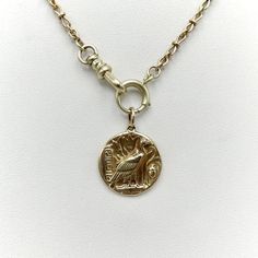 This is part of Chairish’s Fine Jewelry assortment.  This 14k gold medallion charm is part of the Kirsten’s Corner signature “Cute as a Button” collection. It's handcrafted from a Victorian-era button and features the Egyptian vulture goddess Nekhbet.  Nekhbet is the protector of Upper Egypt and its rulers. She is the patron goddess of fertility and childbirth, and was believed to be present at the birth of Osiris. She is referred to as the “Mother of Mothers, who hath existed from the Beginning 14k Gold Amulet Medallion Jewelry, 14k Gold Medallion Amulet Jewelry, Symbolic Vintage Medallion Jewelry With Charm, Antique Gold Coin Pendant Jewelry, Antique Gold Jewelry With Coin Pendant, Heirloom Brass Jewelry With Coin Pendant, Symbolic Yellow Gold Coin Pendant Necklace, Antique Gold Jewelry With Coin Pendant For Collectors, 14k Gold Medallion Necklace Amulet Style