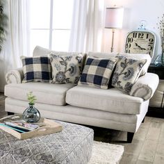 a living room filled with furniture and a large clock on the wall above it's windows