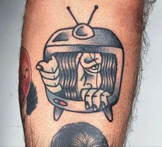 a man with a tattoo on his leg has a tv in the shape of a face